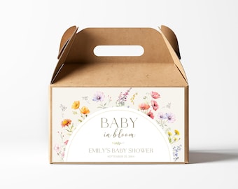 以下が含まれることがあります： 取っ手付きの茶色の段ボール箱で、花柄のデザインと「Baby in bloom Emily's Baby Shower September 23, 2023」の文字が書かれています。