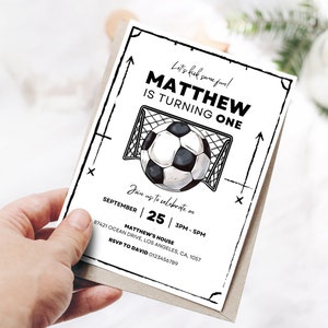 Op de afbeelding: Zwart-witte verjaardagsuitnodiging met een voetbal en een doel. De uitnodiging luidt "Let's kick some fun! Matthew is turning one." De datum is 25 september, 15:00-17:00 uur. Het adres is Matthew's House, 87421 Ocean Drive, Los Angeles, CA, 1057. RSVP aan David 0123456789.