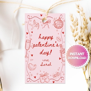 Puede incluir: Etiqueta de regalo imprimible rosa con texto rojo que dice "¡Feliz Día de la Galentín! Con cariño, Sarah" con ilustraciones de corazones, estrellas, copas de champán, un cupido, una bola de discoteca y cerezas.