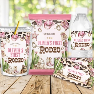 Puede incluir: Un conjunto de suministros para fiestas con temática del oeste, que incluye una bolsa de jugo, una bolsa de patatas fritas, una botella de agua y un envoltorio de barra de chocolate. Cada artículo presenta un diseño de estampado de vaca rosa y marrón con sombreros de vaquero y el texto "Olivia's First Rodeo."