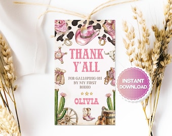 Könnte beinhalten: Ein rosa-weißes Tag im Cowgirl-Thema mit dem Text "Thank Y'all" und "For Galloping on by my first Rodeo". Das Tag zeigt Illustrationen eines Cowboyhuts, Stiefel und eines Sheriff-Abzeichens. Das Tag ist mit Bindfaden gebunden.