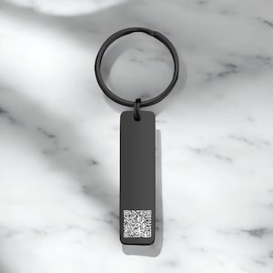 May include: Black metal keychain with a rectangular tag featuring a black and white QR code.