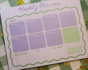 May include: A weekly planner with a white background and a green wavy border. The planner has sections for each day of the week, with a light purple color for the days of the week. The text "Weekly Planner" is written in a light purple script.