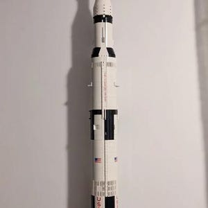 May include: A white and black Lego model of the Saturn V rocket, with the words "USA" and "SATURN V" printed on the side.