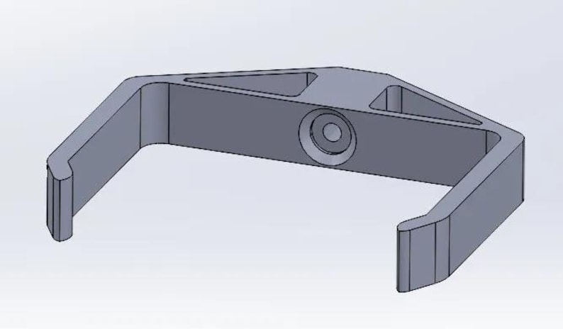 May include: A gray plastic hook with a triangular shape and a round hole in the center.
