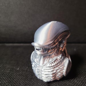 以下が含まれることがあります： 頭部と胴体が詳細に作られた、銀色の3Dプリントされたエイリアンのバスト
