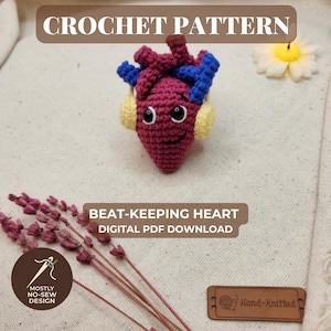 Könnte beinhalten: Eine Häkelanleitung als digitaler PDF-Download mit dem Titel BEAT-KEEPING HEART. Das Bild zeigt ein bordeauxrotes anatomisches Herz-Plüschtier mit blauen und bordeauxroten Gefäßen, schwarzen Sicherheitsaugen, einem Lächeln und gelben Kopfhörern.