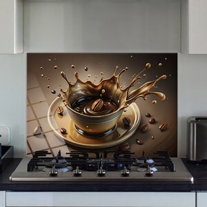 Op de afbeelding: Een keukenachterwand met een digitale illustratie van een koffiekopje en een koffiespat. De beker is bruin en goud, met koffiebonen verspreid. De achtergrond is een bruine en beige gradiënt.