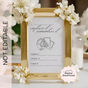 Puede incluir: Un cartel imprimible con un marco dorado y fondo blanco. El cartel dice "En este momento, captúralo, recuérdalo." También tiene una ilustración en blanco y negro de una cámara y una foto. El cartel también tiene instrucciones para que los invitados tomen una foto, la peguen al cartel y la firmen.
