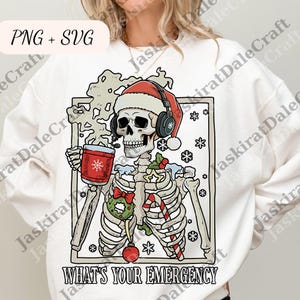 Puede incluir: Sudadera blanca con un gráfico de esqueleto con gorro de Papá Noel y auriculares, sosteniendo una taza roja. El gráfico incluye copos de nieve, un bastón de caramelo y el texto "WHAT'S YOUR EMERGENCY".