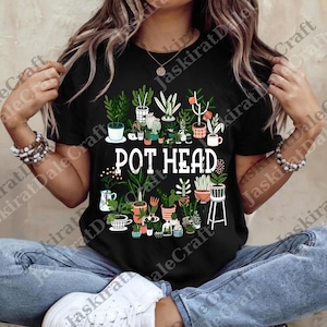 Puede incluir: Camiseta negra con un diseño de plantas en macetas y el texto "POT HEAD" en blanco. El diseño incluye una variedad de plantas verdes en diferentes macetas y recipientes, creando un tema botánico.