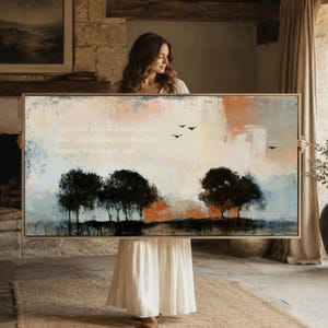 Può includere: Un dipinto paesaggistico rettangolare in una cornice di legno chiaro con uno sfondo astratto nei toni del crema, arancione e blu. Tre alberi scuri in silhouette si ergono in primo piano con uccelli neri in volo e testo stampato a sinistra.