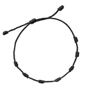May include: Black adjustable bracelet featuring a series of knots along the cord. The bracelet has a simple design with a sliding knot closure for a customizable fit. The cord is a solid black color.