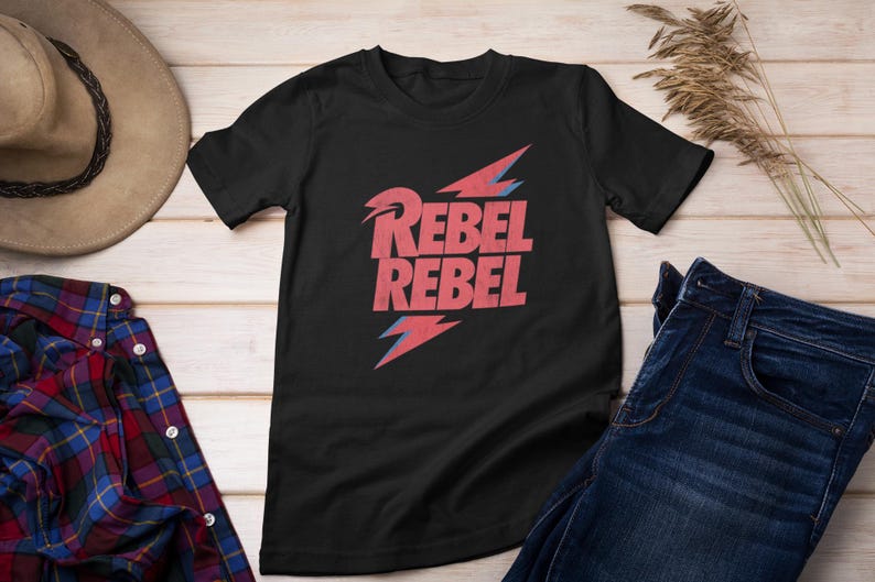 May include: Black t-shirt with a red and blue graphic print of the words "Rebel Rebel" with a lightning bolt design.