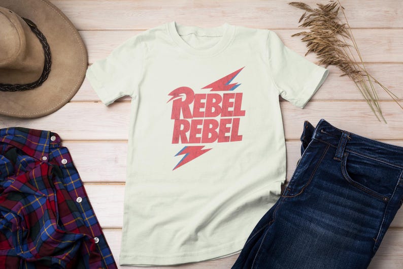 May include: A white t-shirt with a red and blue graphic design that says "Rebel Rebel".