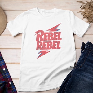 May include: White t-shirt with a red graphic of lightning bolts and the text "Rebel Rebel".