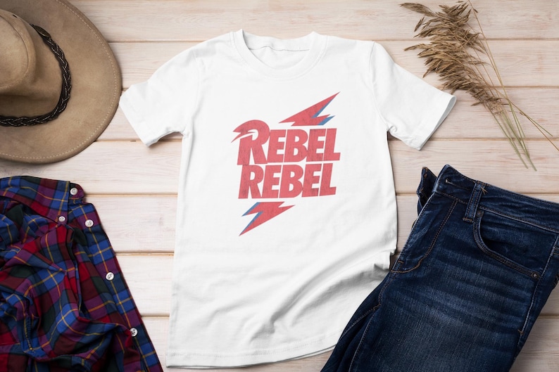 May include: White t-shirt with a red graphic of lightning bolts and the text "Rebel Rebel".