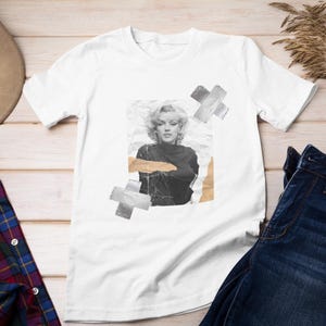Op de afbeelding: Wit T-shirt met een zwart-witte afbeelding van Marilyn Monroe. De afbeelding is omgeven door bruin en grijs tape.