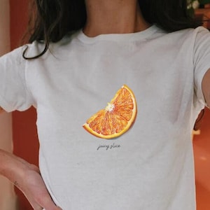 Trendy 90s Baby Tee - Juicy Slice Orange T-Shirt - Vintage Style Citrus Fruit Design - Soft, Snug Fit Retro Fashion for Casual Wear