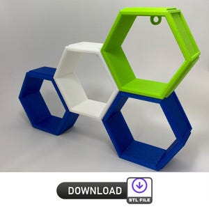 Könnte beinhalten: Drei hexagonale Regale in Blau, Weiß und Grün. Die Regale sind übereinander gestapelt und für die Wandmontage konzipiert.