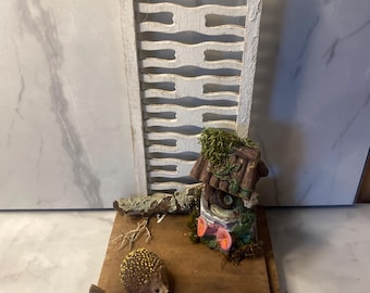 Miniature handmade decorative, with foraged, salvaged or reused items with a well and hedgehog