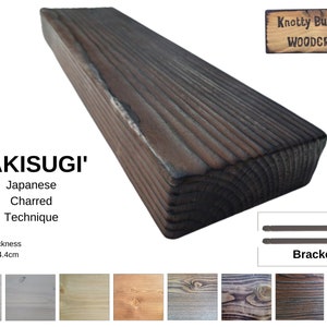 May include: A dark brown, rectangular wooden plank, treated with the Japanese 'Yakisugi' charred technique, is shown. The wood grain is visible, and the dimensions are 16 cm x 4.4 cm. The sign reads "Knotty But Nice WOODCRAFT".