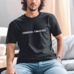 May include: Black crew neck t-shirt with the text "FINANCIAL MISTAKE" in white, blue, and red. The shirt is made of a soft material and is suitable for casual wear. The design is centered on the chest.