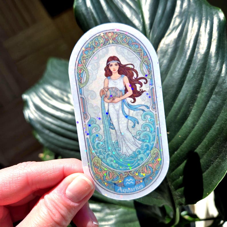Pu&ograve; includere: Un adesivo ovale con un'illustrazione del segno zodiacale dell'Acquario. L'opera raffigura una donna in abito bianco, che tiene una brocca d'acqua, con nastri blu e elementi acquatici. L'adesivo ha un bordo decorativo e la parola "Aquarius".