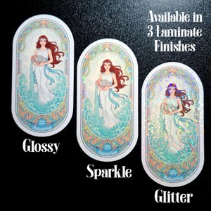 Pu&ograve; includere: Tre adesivi ovali raffiguranti una donna con i capelli rossi e un abito bianco, che tiene in mano un boccale d'acqua. Gli adesivi sono etichettati "Glossy", "Sparkle" e "Glitter". La parola "Aquarius" &egrave; in basso.