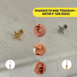 Puede incluir: La imagen muestra pendientes en forma de estrella en tonos dorados y plateados, con un pequeño acento de diamante. Los pendientes se muestran sobre un fondo de tela clara, con primeros planos de los pendientes en la oreja de un modelo. El texto dice: Implant Grade Titanium - ASTM F-136 (G23).
