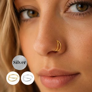 Könnte beinhalten: Ein goldfarbener Nasenring mit zwei Reifen, der im Nasenflügel getragen wird. Das Bild zeigt außerdem ein kreisförmiges Symbol mit dem Text Silver sowie zwei kleine kreisförmige Vorschaubilder des goldenen und eines silberfarbenen Nasenrings.