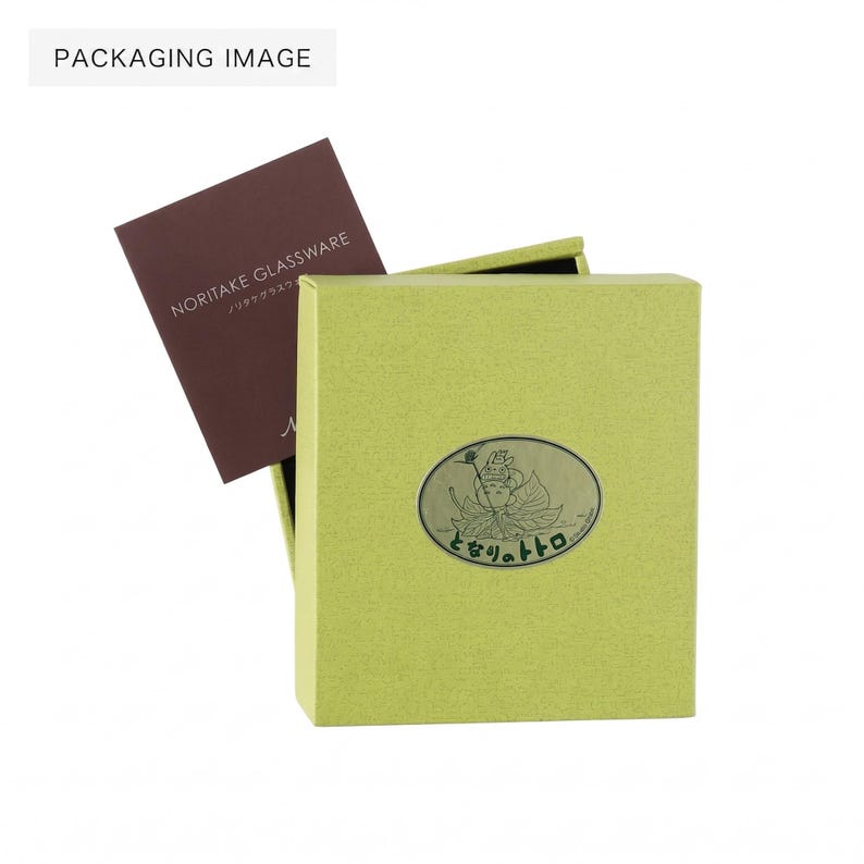 May include: A light green box with a decorative oval emblem and Japanese text. A brown card with the text "NORITAKE GLASSWARE" is partially visible inside the box. The image is labeled "PACKAGING IMAGE".