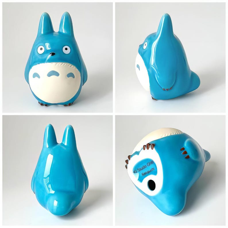 May include: A blue ceramic figurine of Totoro, a character from the animated film My Neighbor Totoro. The figurine has large ears, a white belly, and brown feet. The bottom of the figurine has the text "Studio Ghibli Sousei".