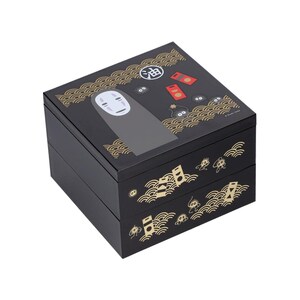 May include: Black, two-tiered box featuring a design from the animated film Spirited Away. The top of the box has an illustration of No-Face and other characters. Gold wave patterns and Japanese text decorate the box.