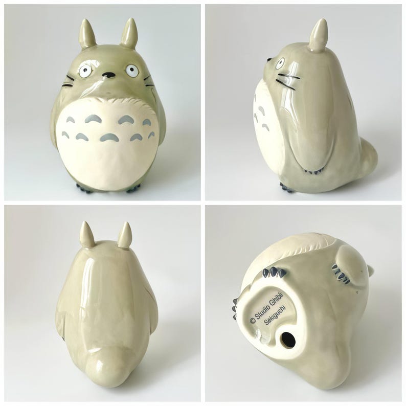 Puede incluir: Figura de cer&aacute;mica de Totoro, personaje de la pel&iacute;cula de animaci&oacute;n Mi Vecino Totoro. La figura es de color gris claro con vientre crema y marcas grises. Tiene ojos grandes, orejas peque&ntilde;as y bigotes negros. La base de la figura tiene el texto "Studio Ghibli Seloguchi".