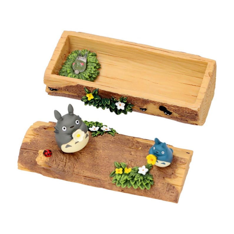 May include: A wooden tray and base set with a rustic, bark-like texture. The set features miniature figurines of characters, including a gray Totoro holding a flower, a blue character, and a small green creature, all surrounded by floral accents.