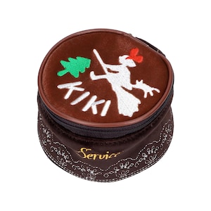May include: A brown, round, zippered case with embroidered Tiki-themed designs. The top features a white figure, a green tree, and the word "Tiki" in white. The bottom section has a floral pattern and the word "Service" in gold.