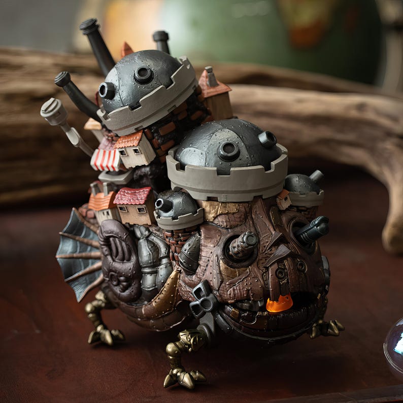 May include: A detailed, steampunk-inspired figurine of a creature with a fortress on its back. The figure features a brown and bronze color scheme, with miniature houses, turrets, and mechanical details. The creature has fin-like structures and clawed feet.