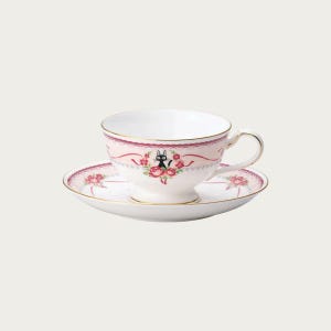 May include: A white teacup and saucer set with a pink floral design and gold trim. The teacup features a black cat illustration surrounded by roses. The saucer has a matching floral pattern, creating a charming and elegant tea set.
