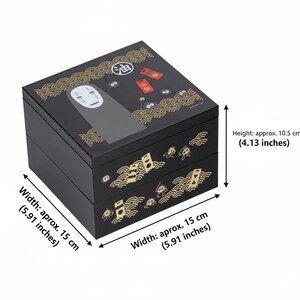 May include: Black, two-tiered box with a decorative design. The top features a character illustration and Japanese text. The box is 5.91 inches wide and 4.13 inches tall.