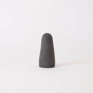 Puede incluir: Un objeto s&oacute;lido de color gris carb&oacute;n oscuro con una parte superior redondeada y lisa y una base ancha y plana. El art&iacute;culo tiene una superficie mate ligeramente texturizada y una silueta c&oacute;nica que se mantiene erguida sobre un fondo claro.