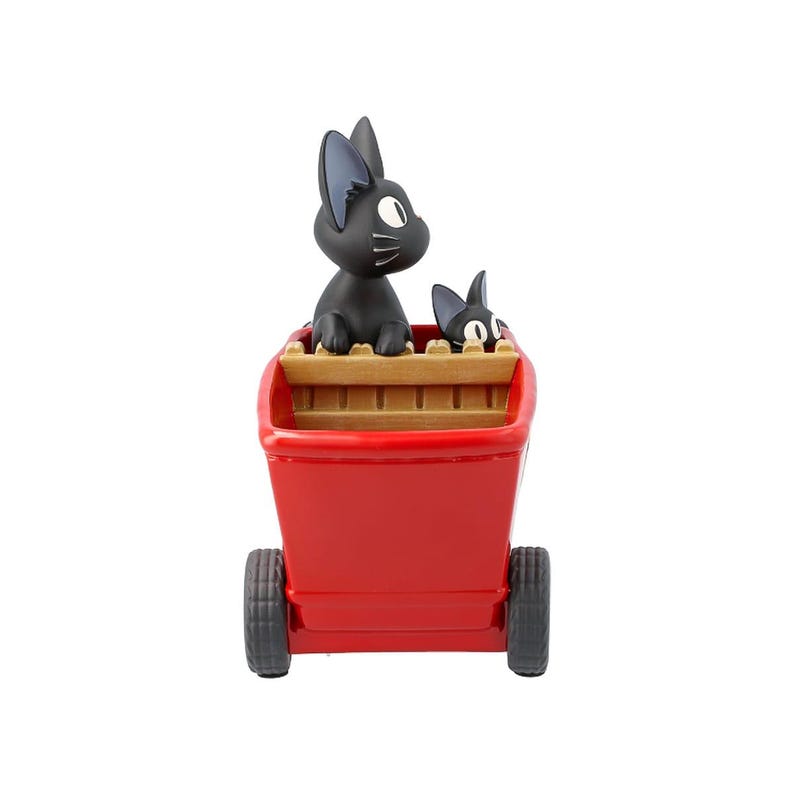 May include: A red wagon with two black cat figurines. The wagon has two black wheels and a wooden interior. One cat is larger and upright, while the other is smaller. The cats have white eyes and gray ears.