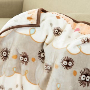 Peut inclure: Une couverture douce et moelleuse avec un motif r&eacute;p&eacute;t&eacute; de cr&eacute;atures de dessins anim&eacute;s aux grands yeux et aux cheveux h&eacute;riss&eacute;s. La couverture a un fond gris clair et blanc avec une bordure marron et des accents orange et bleu.