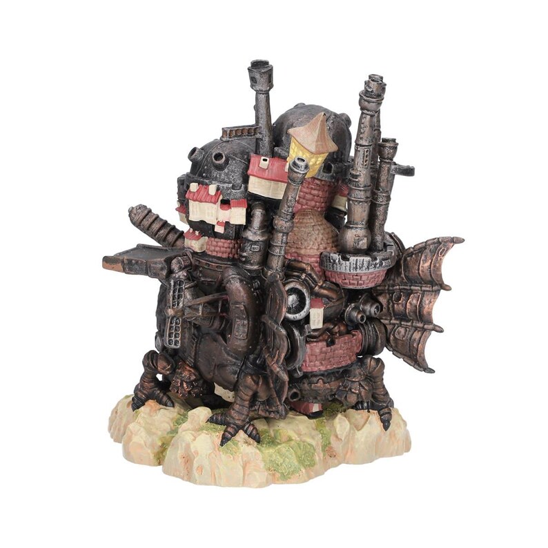 May include: A detailed, steampunk-inspired sculpture of a fantastical vehicle or building. The structure features a mix of dark metal, brick, and light-colored accents. It has multiple chimneys, a fin-like structure, and sits on a textured base.