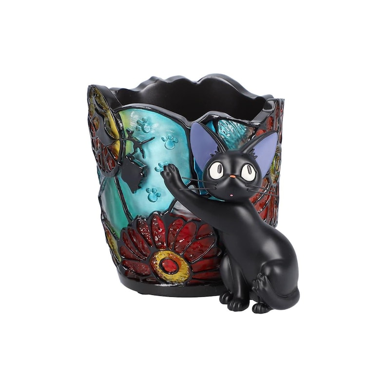 K&ouml;nnte beinhalten: Schwarze Katzenfigur mit blauen Ohren, die aus einem bunten Bleistiftbeh&auml;lter aus Keramik im Stil von Buntglas schaut. Der Beh&auml;lter ist mit roten, blauen, gelben und gr&uuml;nen Blumen verziert.