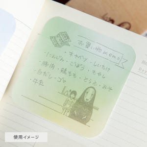 May include: A square, light green gradient sticky note featuring a printed shopping list in Japanese text. The note includes a small illustration of two characters at the bottom and a banner at the top with the text Okaimono memo.