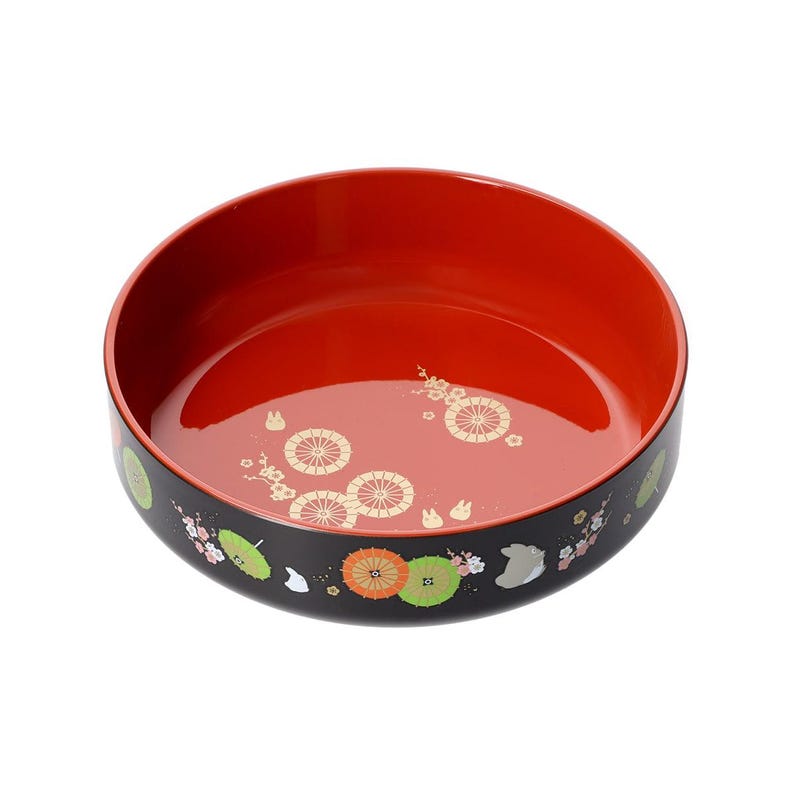 May include: A round, lacquered bowl with a vibrant red interior and a black exterior. The bowl is adorned with gold and white floral and geometric patterns. The rim features colorful illustrations of umbrellas and flowers.
