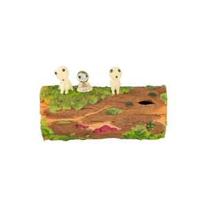 Pode incluir: Um tronco de madeira decorativo com tr&ecirc;s pequenas figuras brancas e brilhantes com olhos pretos. O tronco &eacute; coberto de musgo verde e tem um aspeto natural de gr&atilde;o de madeira. As figuras s&atilde;o de tema florestal.