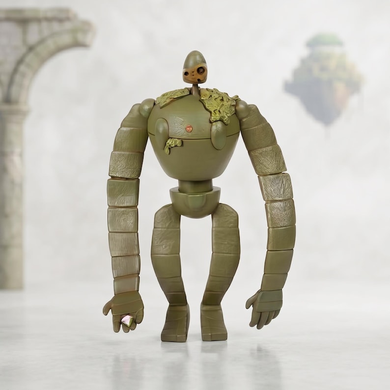 Peut inclure: Figurine de robot vert olive avec des membres segment&eacute;s et un torse rond. La figurine a une petite t&ecirc;te et une croissance v&eacute;g&eacute;tale sur l'&eacute;paule. Le robot est debout, les mains ouvertes, et une bague est visible sur un doigt.