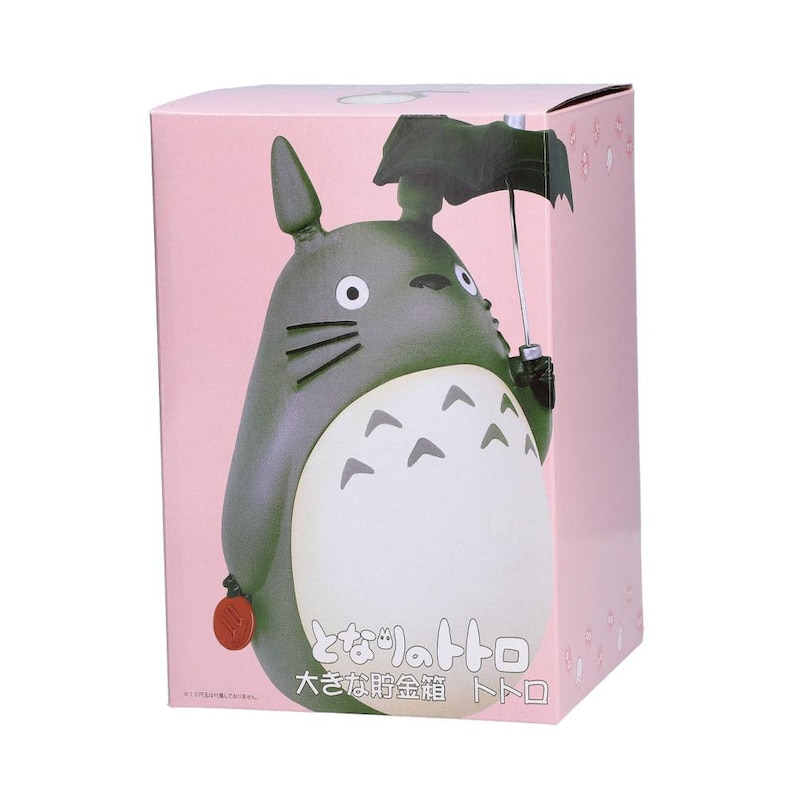 Puede incluir: Una caja de producto rectangular de color rosa con un gr&aacute;fico de un personaje Totoro gris que sostiene un paraguas negro. El personaje tiene una barriga blanca con marcas de gal&oacute;n grises, bigotes y orejas puntiagudas.